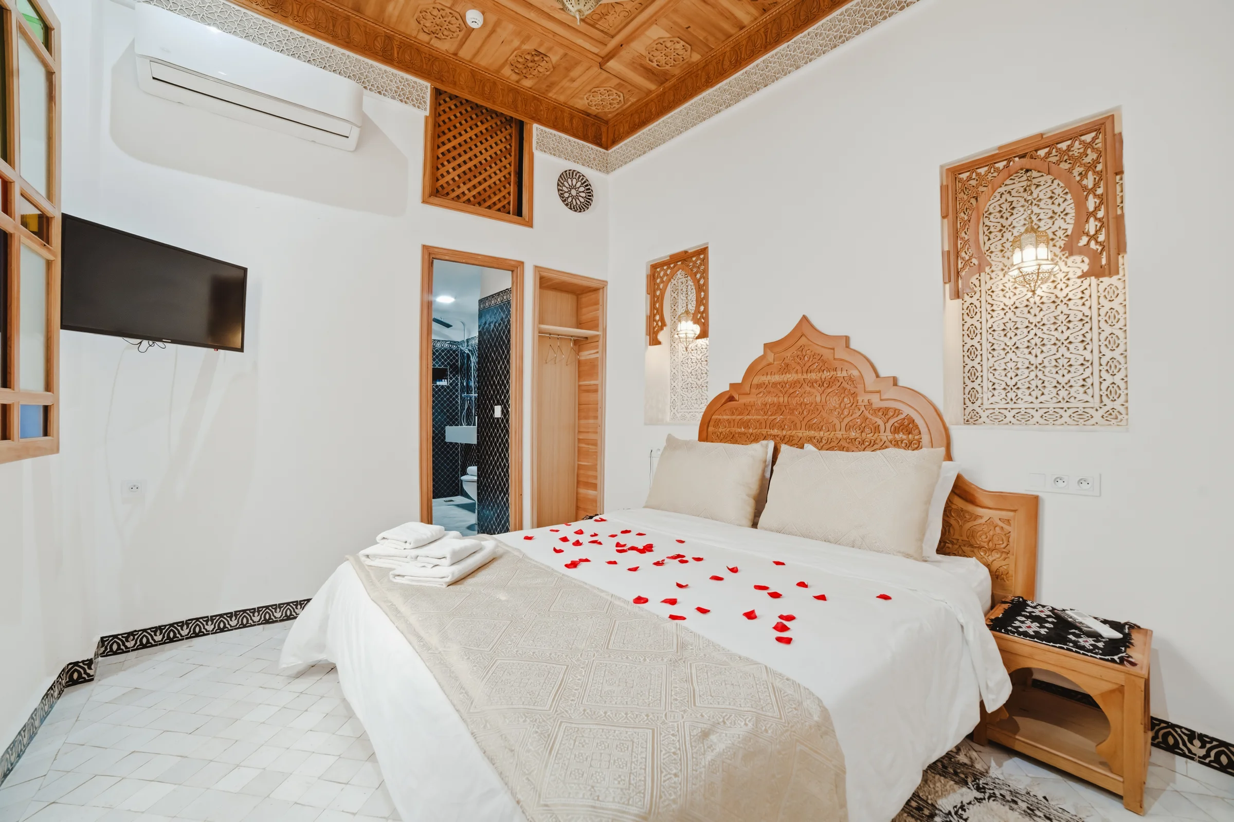 Riad bedroom with a bed decorated with rose petals