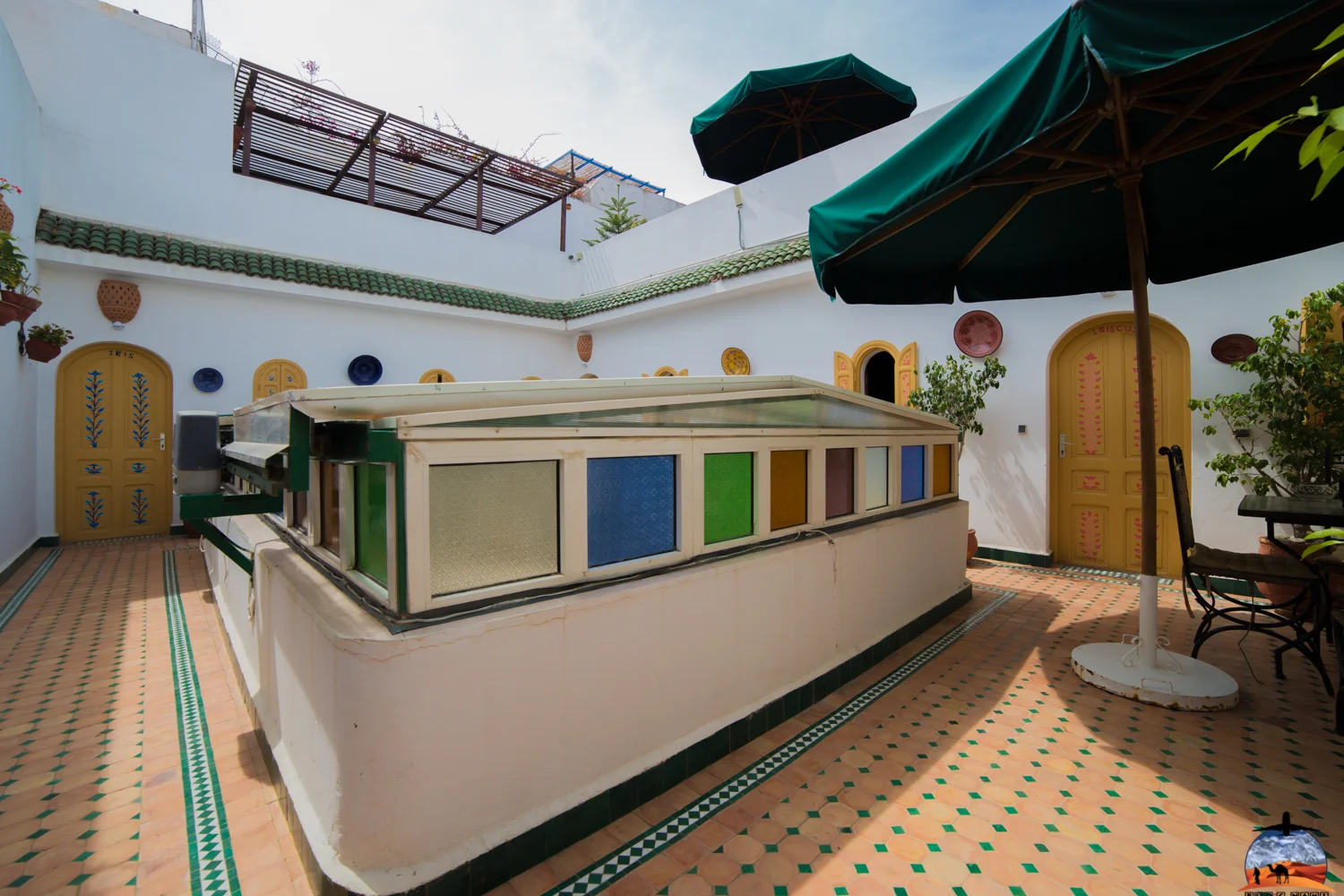 Riad terrace with a counter and green parasols
