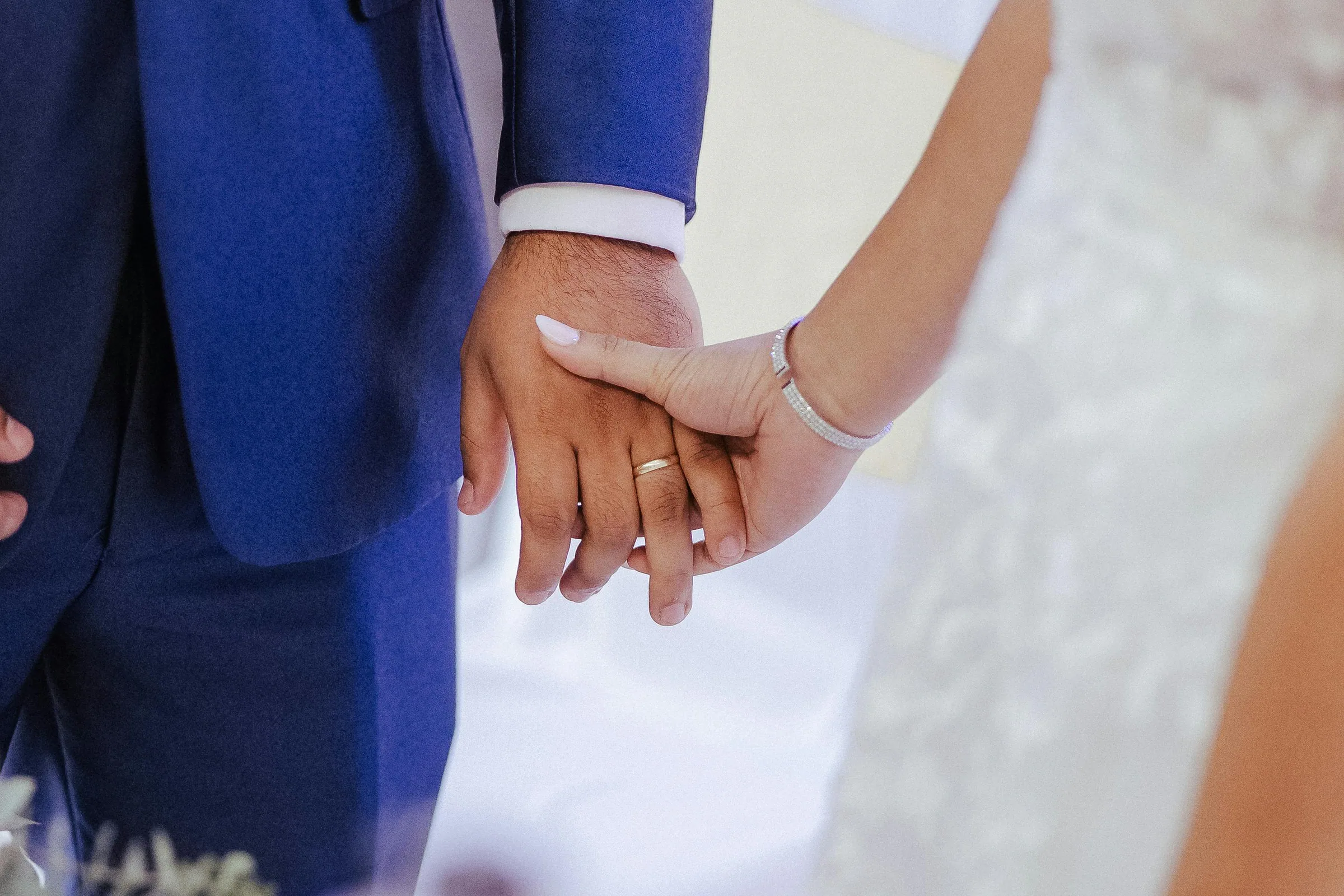 Les mains d’un couple portant leurs alliances