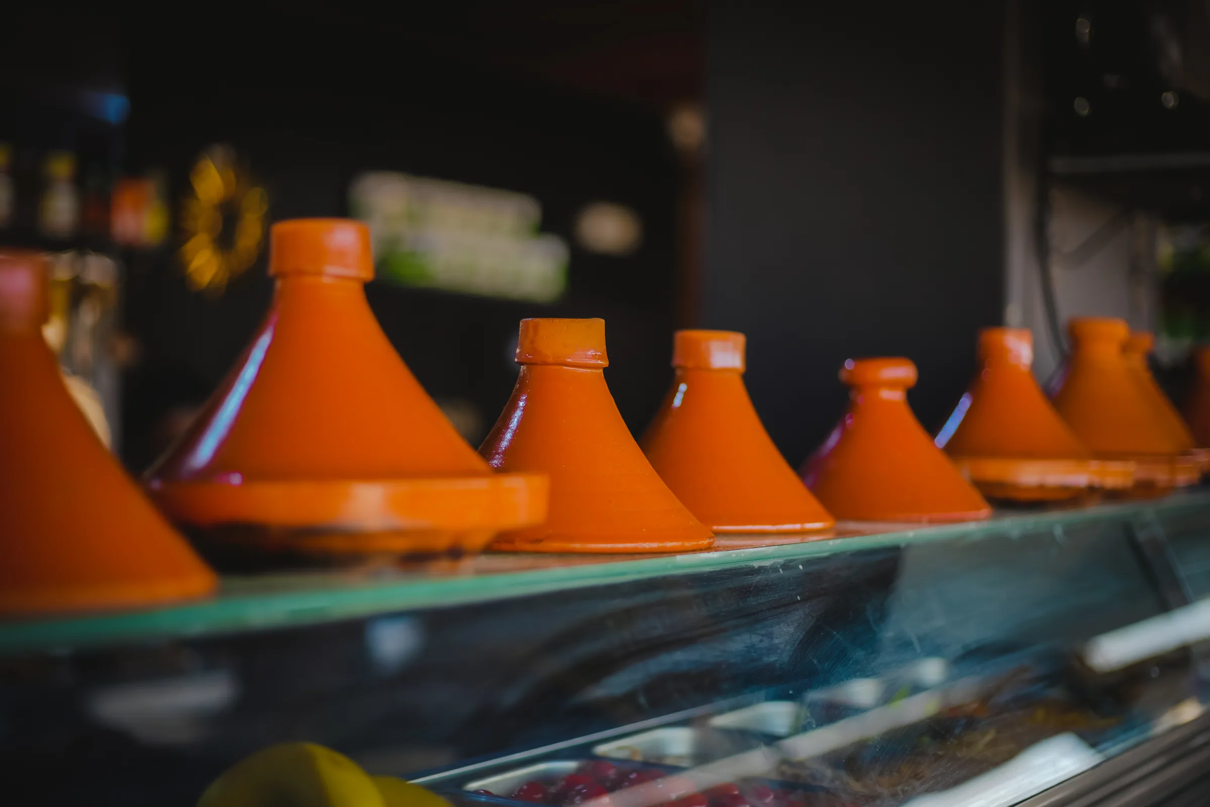 Row of clay tagines along the kitchen pass