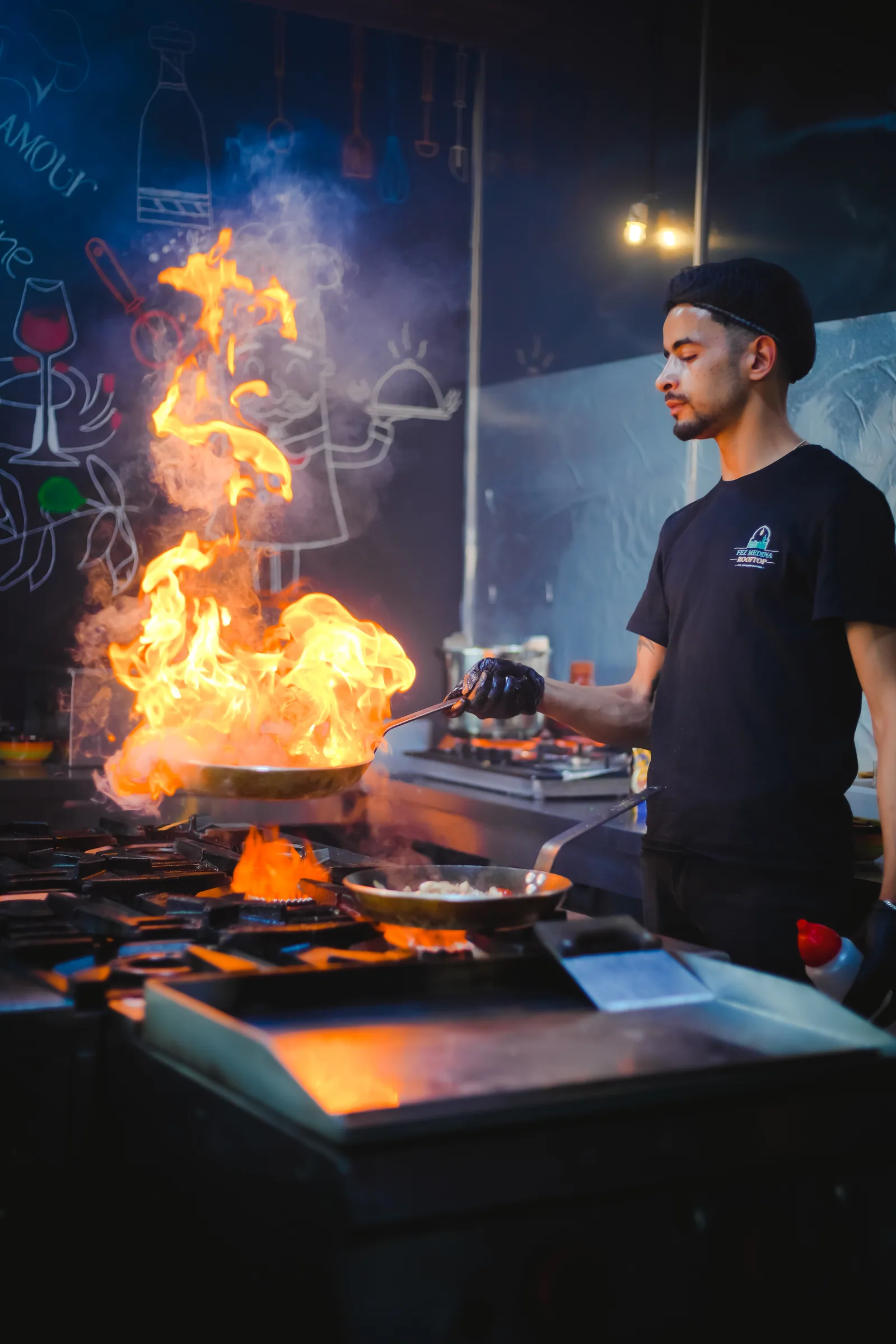 Chef devant une flambée en cuisine ouverte