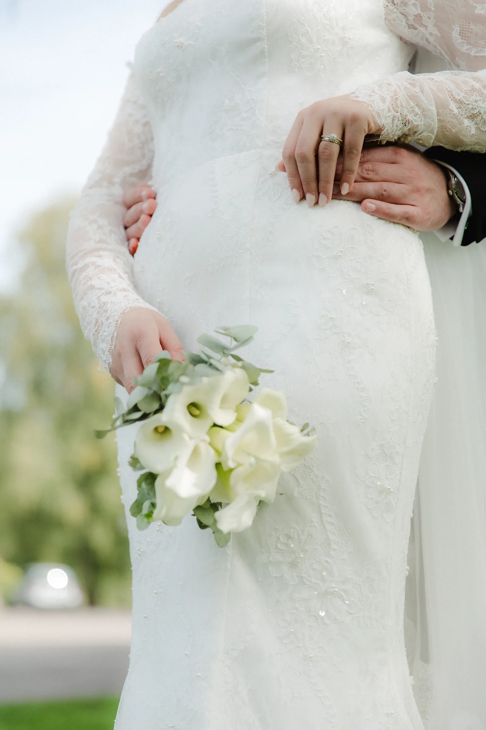 Mains du couple et bouquet pendant un portrait de mariage